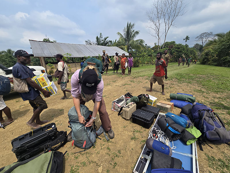 Emmeline Norris preparing gear on the way to Yomoum village